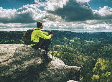 Backpacker arka görünümü kenarda oturup. Ayak yolunun sonu 
