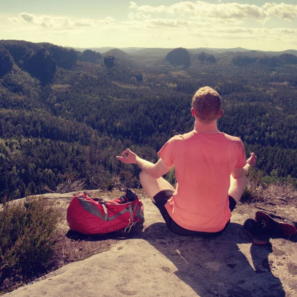 Man vandrare sitter på toppen av berget i yoga pose — Stockfoto