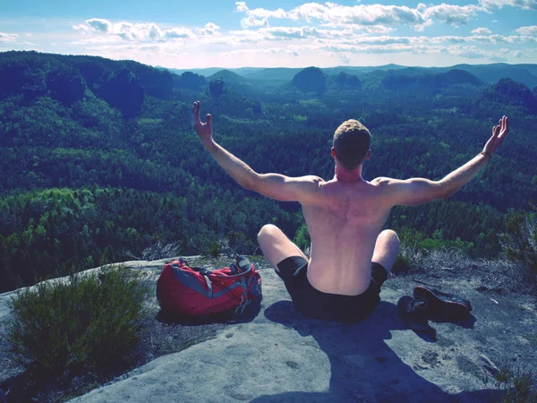 Shirtless man relaxing meditation with serene view mountains