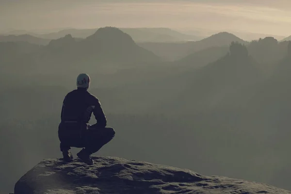 Active midle age tourist or runner sits on the edge of a rock — Stock Photo, Image