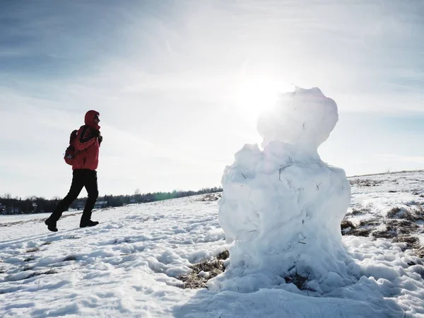 El hombre camina en el muñeco de nieve helado derritiéndose en lugar nevado — Foto de Stock