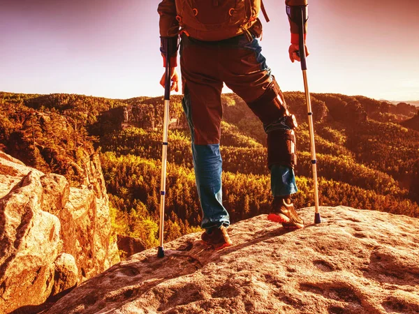 Magoar o homem forte de pé com muletas no cume da montanha . — Fotografia de Stock