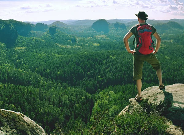 Sportsman stay in akimbo pose looking into hilly landscape — Stock Photo, Image