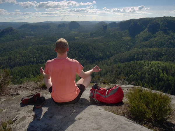 Middle-aged man practicing yoga and meditation in mountains