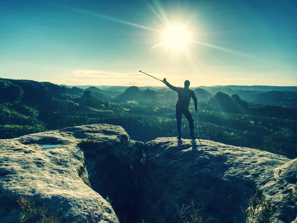 Blesser un homme fort debout avec des béquilles sur le sommet de la montagne . — Photo