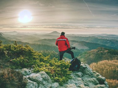 Uçurumda tripod ve kamera ile Fotoğrafçı ve düşünme