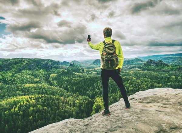 Homem turista caminhadas trilha de montanha, tira foto por telefone . — Fotografia de Stock