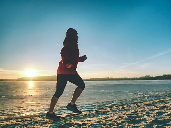 Uma mulher desportiva. Corredor feminino correndo na baía de inverno — Fotografia de Stock