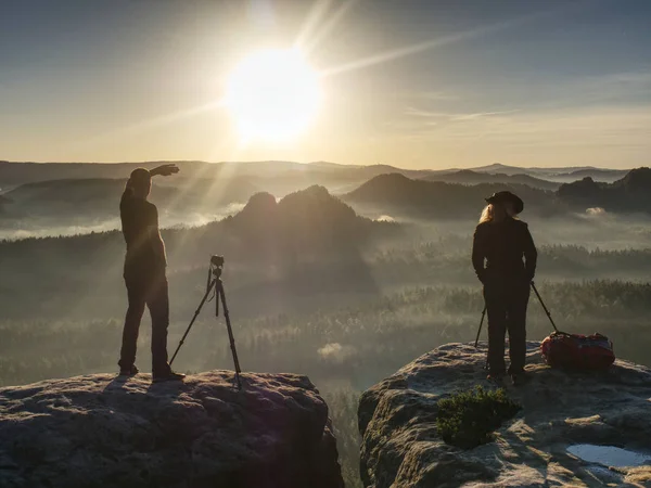 两个徒步旅行者在山顶上拍照和交谈。两位摄影师 — 图库照片