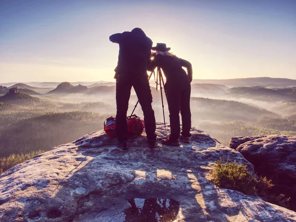 Two hikers taking pictures and talk on top of mountain. Two photographers — Stock Photo, Image