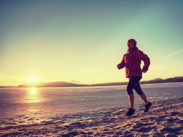 Bieganie lub jogging na plaży zimą, słoneczny dzień rano — Zdjęcie stockowe