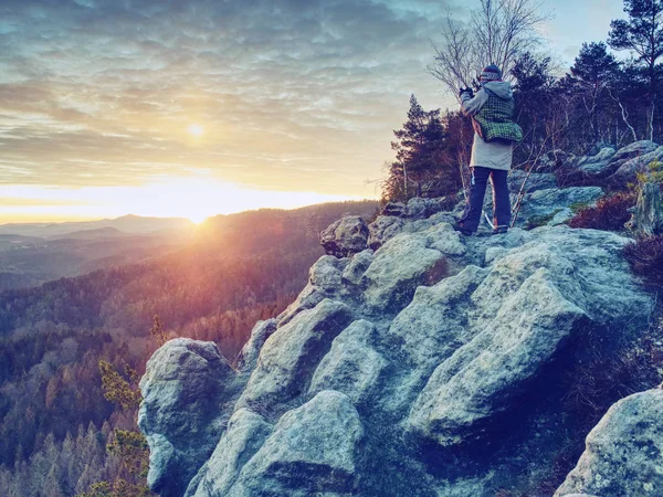 Hiker woman photographer takes photos from sharp cliff edge — Stock Photo, Image