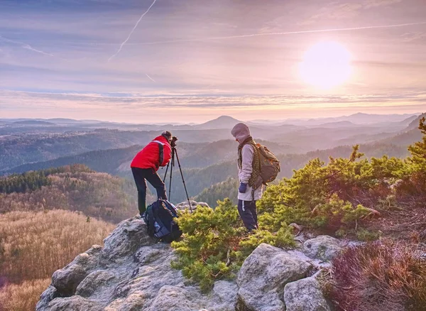 Due persone soggiornano al treppiede sullo sfondo di una catena montuosa — Foto Stock