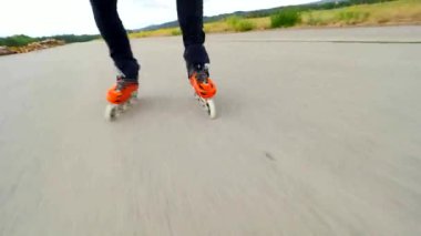 Yazın paten kaymak. Hradcany havaalanı, 9 Temmuz 2019, Güneşli bir günde asfalt üzerinde Turuncu sert kabuk paten. Şehrin dışına doğru sıralı paten. Eğlenceli serbest zaman etkinliği. 