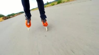 Yazın paten kaymak. Hradcany havaalanı, 9 Temmuz 2019, Güneşli bir günde asfalt üzerinde Turuncu sert kabuk paten. Şehrin dışına doğru sıralı paten. Eğlenceli serbest zaman etkinliği. 