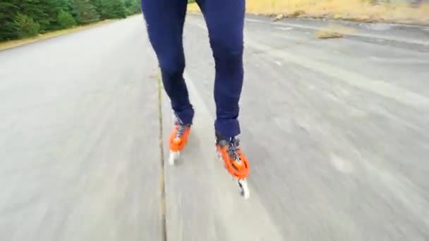 コンクリートエアロドローム表面でスケートする男性の足 2019年7月9日 フラドカニー空港 インラインスケート オレンジ色のハードシェルインラインブーツの素早い動きにビューを閉じる — ストック動画