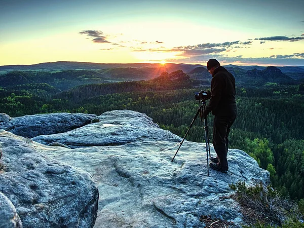 Fotografo sulla scogliera di montagna scattare foto di paesaggio risveglio . — Foto Stock