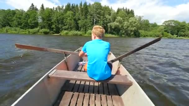 Хлопчик Синьому Кольорі Рятувальними Жилетами Ногах Плаває Судновому Човні Жорстко — стокове відео