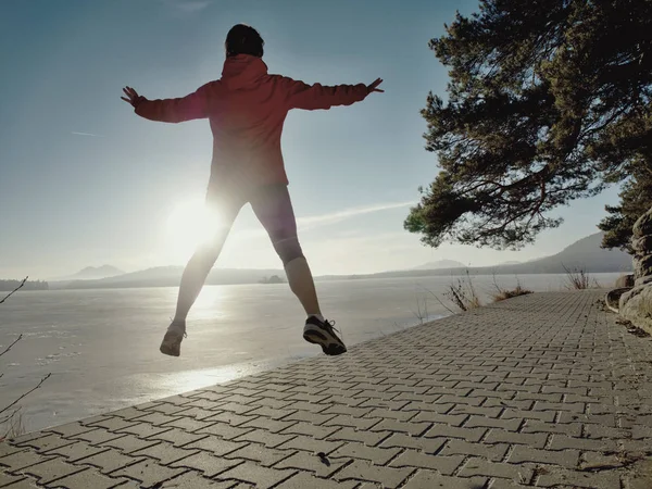 Спортивна фітнес-леді стрибає і бігає на пляжі на заході сонця . — стокове фото