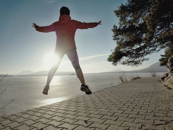 Fitness athlétique femme sauter et courir sur la plage au coucher du soleil . — Photo