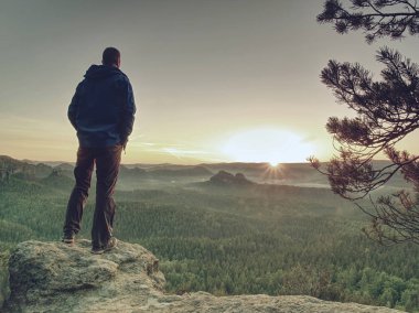 İnce adam tepede yükselen Sun vadi üzerinde izliyor
