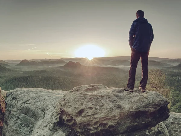 Slim guy on peak  watching over  valley to rising Sun — Stock Photo, Image