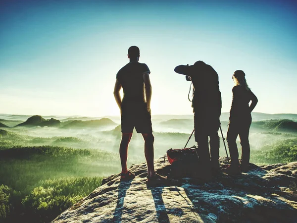 Caminante con dos fotógrafos en la cumbre observan amanecer en el horizonte — Foto de Stock