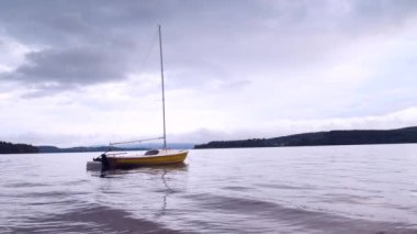 Sakin suda bir tekne. Sahil kenarındaki su yatında. Boş yat ve mavi sessiz su