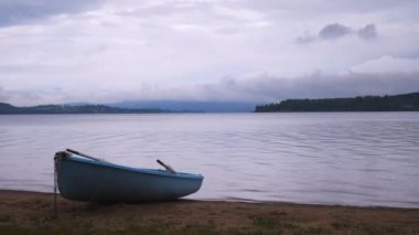 Eski balıkçı kürek tekne Lipno gölün büyük pürüzsüz su seviyesinde ağacın altında yığılmış. Popüler tatil beldesinde sakin rüzgarsız akşam.