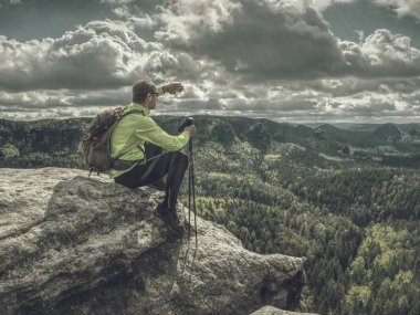 Backpacker arka görünümü kenarda oturup. Ayak yolunun sonu 