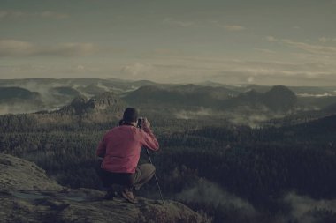 Kampın yakınında kamera standı ile adam fotoğrafçı silueti