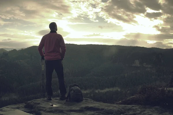 Sportowy człowiek na szczycie góry patrząc na górskiej dolinie — Zdjęcie stockowe