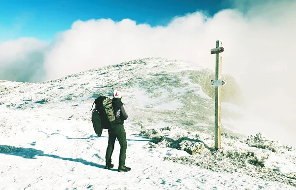 Wanderer mit Rucksack und Schneeschuhen wachen im verschneiten Gebirge auf — Stockfoto