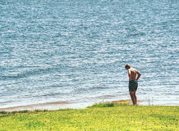 소년은 무릎 아래 물과 호수에 머물고 온도를 테스트 — 스톡 사진