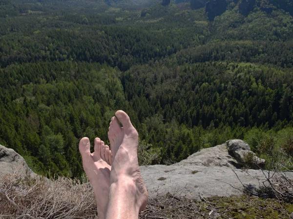 Vue sur ses propres jambes au mot. Rocher de grès au-dessus de la vallée — Photo