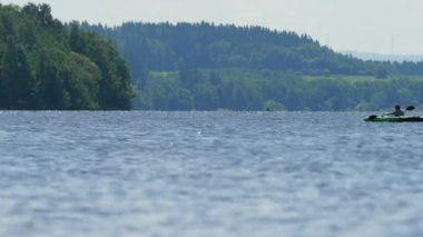 Kayıkta can yeleği giyen genç. Harika gölde güneşli bir gün. 15 Temmuz 2019, Lipno gölü, Çek Cumhuriyeti. Yaz saati