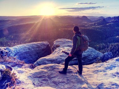 Kayalık bir zirvede gün doğumu. Sanatçı doğada çalışıyor