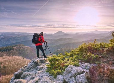 Adam tripod tutun. Yürüyüşçü çarpıcı dağ hayran