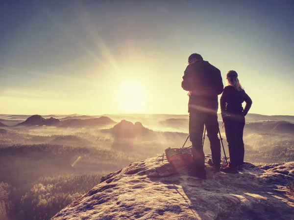 Пара туристів з фотокамерою на вершині гірського годинника захід сонця — стокове фото