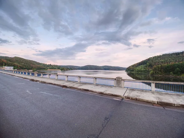 ダムの水位に歩道橋の手すりを見渡します。夕方の空 — ストック写真