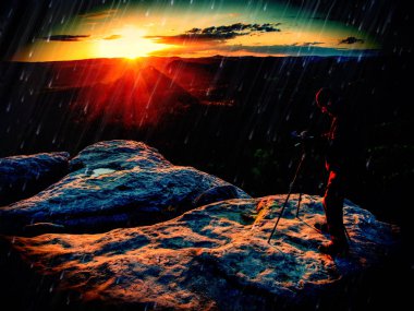 Sunrise on a rocky summit. Artist works in nature clipart