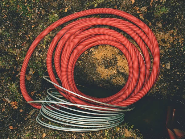 Tuyaux en plastique rouge nervuré contenant des câbles électriques — Photo