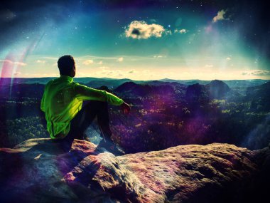 Adam arka plan tepeler ve bulutlar dağ zirvesinde dinlenme