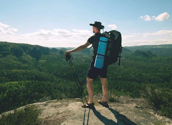 Reisende mit Rucksack und Stöcken blickt auf Berggipfel — Stockfoto