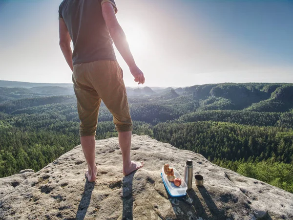 Homem freie para lanche enquanto sobe em rochas. Caminhante em shorts Fotografias De Stock Royalty-Free