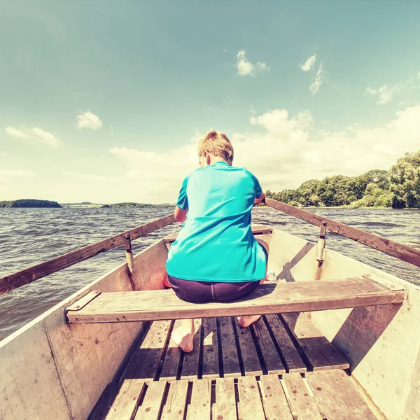 Garçon en bleu avec gilets de sauvetage aux jambes flotteurs sur bateau bateau — Photo