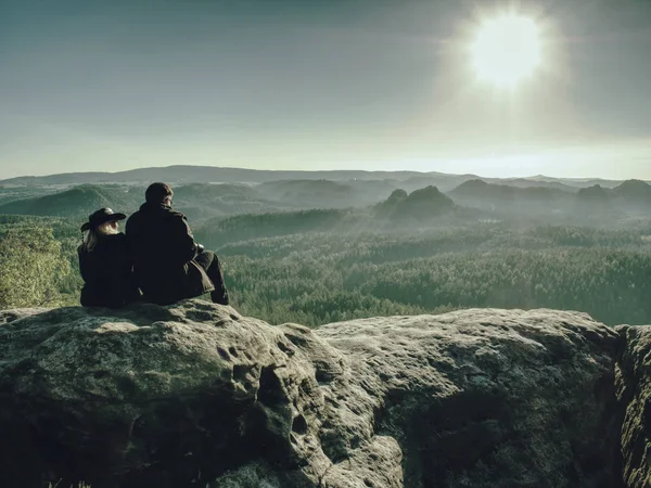 Два туриста на вершине холма смотрят на горы — стоковое фото