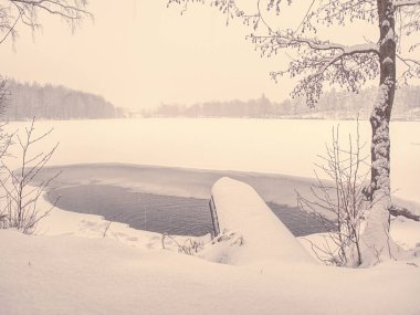 Çözülmüş kış gölü. Yarı donmuş gölet ve yürüyüş