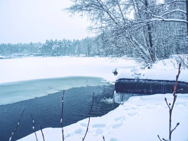Çözülmüş kış gölü. Yarı donmuş gölet ve yürüyüş