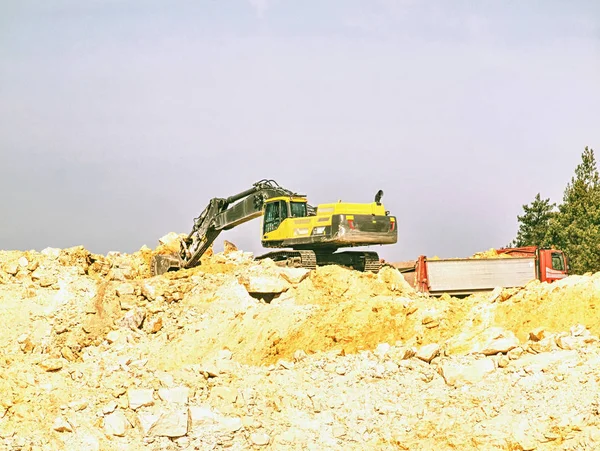 Pesado caminhão basculante de carregamento escavadeira com areia na areia — Fotografia de Stock